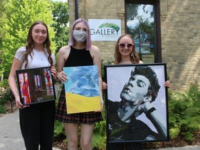Recipients of this year's Gallery in the Grove scholarships hold examples of their work outside the gallery in Bright's Grove. From left: Carly Chartrand, Ainsley Wrobel and Mariah Dennis. Absent from the photo is scholarship winner Clay LeBlanc. Paul Morden/Postmedia Network