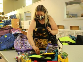 Adrienne McPhee, program manager at the Inn of the Good Shepherd, packs one of the 1,000 back-to-school kits the Inn is assembling this year for local families in need. It's one of the services provided by the Sarnia agency and supported by donations and fundraisers, including its Local Shopping Spree Raffle. Paul Morden/Postmedia Network