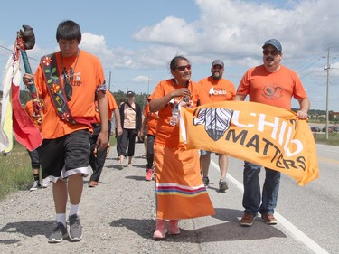 The Walk of Sorrow arrived in Timmins Sunday, led by residential school survivor Patricia Ballantyne, seen here in the middle as the procession was heading south on Highway 655. They eventually made their way to Hollinger Park where Timmins Coun. Cory Robin, seen here on the right, served as the master of ceremonies for the event.

RON GRECH/The Daily Press