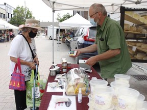 Denis Nadeau, manager of sales and marketing with the Fromagerie Kapuskoise, was providing information about the company's artisan cheese to Pauline Desjardins at his booth during the Urban Market on Thursday. 

RICHA BHOSALE/The Daily Press