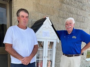 Jeff Robinson, president of the Bayham Historical Society, (right) accepts the donation of a book cupboard that was assembled and donated by Dale (on the left) and Patti Collinson of Collinson Construction in Corinth. The cupboard, which is now stocked with Canadian historical books, is located in front of the Edison, Vienna and Area Museum located at 6209 Plank Rd, Vienna. (Submitted)