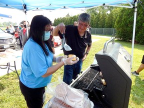 Walpole Island Chief Charles Sampson helped out cooking up burgers for the many celebrants who attended the Bkejwanong Gas & Convenience grand opening. Carl Hnatyshyn/Postmedia