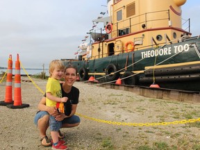 Kaden Hayward, 3, and his mother, Jessica Hayward of Sombra, stand next to Theodore TOO at the Mooretown Dock on Aug. 26. Paul Morden/Postmedia Network