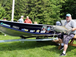 Owen Sound Salmon Spectacular co-chair Chris Geberdt holds the 2019 top-prize salmon, a 29.5-pounder caught by Wayne Hollett of Wroxeter, and sits beside the Fred J. Geberdt Rainbow 1, a prize boat for the top rainbow trout to be caught at this year's derby in memory of Geberdt's father and derby founder. The 33rd Annual Owen Sound Salmon Spectacular sponsors appreciation event was held Thursday at the Sydenham Sportsmen Association Clubhouse Greg Cowan/The Sun Times