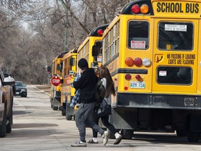 Churchill Hill students pass school buses on Hay Street in Winnipeg on Monday, March 15, 2021.