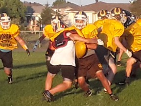 The Korah Colts football team is shown here practicing on Tuesday night at their high school football field. Training camp for all the high-school football teams in the city began earlier this week.