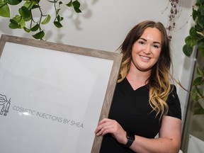 Shea Cassidy holds a sign for her new medical aesthetic business Tuesday. Cosmetic Injections by Shea first began two months ago in Belleville, Ontario, from Cassidy's passions in making patients feel confident in their appearance. ALEX FILIPE