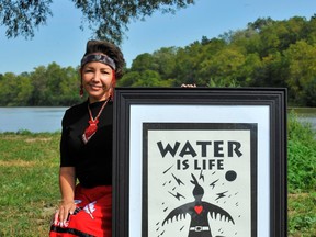 Pleasure mixed with politics at a Grand River paddle event at Chiefswood Park in Six Nations of the Grand River Saturday. Helping promote a message of clean water and environmental stewardship was jeweller and bead worker Vanessa Brousseau of Hamilton. – Monte Sonnenberg
