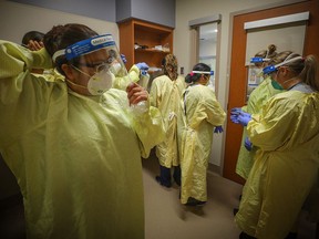 Nurses prepare to treat a COVID-19 patient on the intensive care unit at Peter Lougheed Centre in Calgary on Nov. 14, 2020. Photo by LEAH HENNEL / Alberta Health Services.