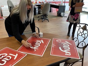 Local Liberal candidate Tanya Holm paints over red spray paint that vandalized her campaign signs. She had more than 100 signs vandalized or stolen. Photo via Twitter