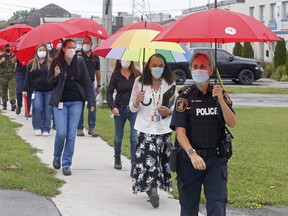 United Way campaign chair Sheri Meeks, a Belleville police inspector, leads a parade of umbrella-carrying supporters of the charity Wednesday along Wallbridge Crescent in Belleville. The charity aims to raise $1.95 million for local social service agencies.