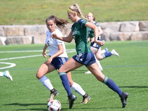 Zoe Derkach of the Nipissing Lakers takes the ball up the field while Megan Short of the Laurentian Voyageurs tries to intercept in OUA action at the Nipissing Soccer Field, Saturday. The Lakers defeated Laurentian 1-0.
