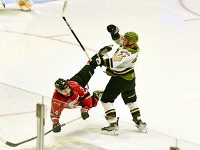 Rookie defender Ty Nelson of the North Bay Battalion dumps Thomas Chafe of the visiting Owen Sound Attack in Ontario Hockey League preseason action Saturday. The Troops doubled the visiting Attack 4-2. Sean Ryan Photo