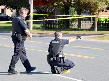 Sault Ste. Marie Police Service investigate a shooting incident that left a man dead and a police officer seriously injured near 696 Pine St., in Sault Ste. Marie, Ont., on Sunday, Sept. 19, 2021. Sgt. Geoff MacLeod speaks with a forensics officer. (BRIAN KELLY/THE SAULT STAR/POSTMEDIA NETWORK)