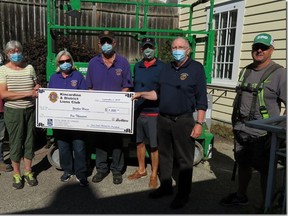 Flanked by Bird Construction workers, Lion President Paul Thompson presents a cheque to Sylvia Leigh, fundraising chair, of the ongoing Walker House restoration project. Lions Joan Thompson, Larry Bannerman and Peter Morris assist. SUBMITTED