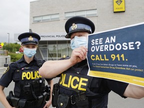 Quinte West OPP Consts. Maggie Pickett and Devin Leeworthy promote the Good Samaritan Drug Overdose Act at the detachment in Trenton, Ont. The act provides some legal protection from certain drug and breach charges when reporting overdoses.