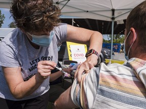 A visitor to the Prince Edward Agricultural Society's Fall Drive Thru Festival gets his first shot of the Pfizer-BioNTech COVID-19 vaccine from a member of the Prince Edward Family Health Team Sept. 11 in Picton.