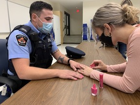Special Const. Chris Dahlke of the North Bay Police Service gets his nails painted pink Thursday at police headquarters to help kickoff the CIBC Run for the Cure, which takes place Oct. 3. North Bay police issued a challenge to the fire department and paramedics. Chief and deputy of the losing team will have to have their nails painted pink.