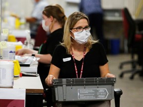 A special ballot officer in Ottawa holds a box of ballots last Monday received by mail during the federal election. REUTERS/Patrick Doyle