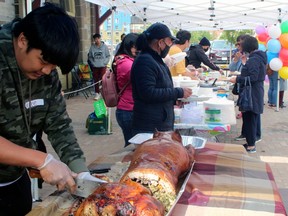 Mike Sanchez cuts up 'lechon,' the national dish of the Philippines, at the Filipino Fiesta, Sunday, as part of Nipissing Culture Days. PJ Wilson/The Nugget