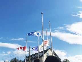 The Town of Peace River, Treaty 8, and Metis flags were at half-mast for the Every Child Matters gathering held June 21, 2021 at the Treaty 8 monument in downtown Peace River. The Third Mission Inn and Suites, formerly the Priest's Residence from the St. Augustine Catholic Mission on the Shaftesbury Trail, is in the background.