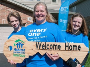 Claire Miller-Grosse and her children Cameron, 16, and Megan, 13, celebrate in front of their new home in Stratford on Wednesday. After first reaching out to Habitat for Humanity in 2018, the family of three is preparing to move in at the end of the week. Chris MontaniniStratford Beacon Herald