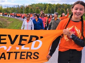 Members of Tyendinaga Mohawk Territory walk Thursday in an event organized by the Tyendinaga Native Women's Association to promote healing and positivity on the first National Day for Truth and Reconciliation. ALEX FILIPE