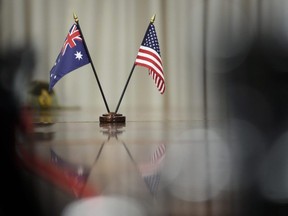 Australian and American flags sit on the table during a meeting between Prime Minister of Australia Scott Morrison and U.S. Secretary of Defense Lloyd Austin at the Pentagon on September 22, 2021 in Arlington, Virginia. Last week, Australia, the United States and the United Kingdom announced a security pact (AUKUS) to help Australia develop and deploy nuclear-powered submarines, in addition to other military cooperation. (Photo by Drew Angerer/Getty Images)