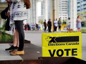 People line up outside a polling station to vote in Canada's federal election on September 20, 2021. (REUTERS/Mark Blinch)