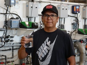 Anthony Green, the water treatment plant's operator, holding up a clean glass of drinkable water.