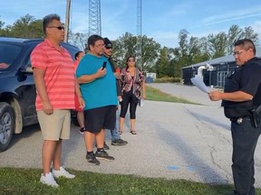 Colin Martin, left, and other protesters at the Gathering Place on Six Nations, handed out copies of a Haudenosaunee Confederacy Council letter issued last week to police and Elections Canada workers who were preparing to welcome voters on Six Nations. The polls there were closed and moved to Oakland Community Centre.