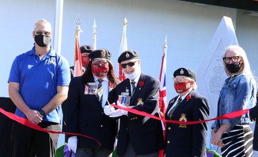 Royal Canadian Legion Branch 564 first vice-president Eddie Thompson, centre, cuts a ribbon during a dedication ceremony for the Lockerby Legion's expanded cenotaph, which now includes two granite memorial walls in tribute to deceased veterans who were members of the branch, as well as paver stones dedicated to legionnaires, veterans and their loved ones, in Sudbury, Ontario on Saturday, September 18, 2021. Thompson was the visionary behind the project. Ben Leeson/The Sudbury Star/Postmedia Network