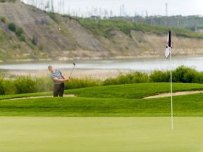 A golfer takes a shot onto the green during the Canadian Men's Med-Amateur Championship. Image by Fort McMurray Wood Buffalo Economic Development and Tourism