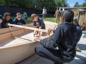 Tyler Groat, 11, attaches a keel to a rowboat Friday during a youth ship building project at the Periscope Playhouse in Port Burwell. The week-long exercise, run by a community organization called Stem2Stern, introduces grade 5-8 students to woodworking skills by crafting boats. (Derek Ruttan/The London Free Press)