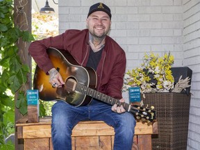 Aaron Allen of London is flanked by Country Music Association of Ontario awards for male artist of the year and album of the year he picked up over the weekend. (Derek Ruttan/The London Free Press)