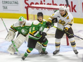 Brett Brochu of the London Knights keeps his eye on the puck while Denver Barkey keeps Nolan DeGurse of the Sarnia Sting from the front of the net during the first Knights exhibition game at Budweiser Gardens in London, Ont., on Friday, September 3, 2021. Mike Hensen/The London Free Press/Postmedia Network
