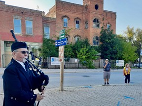Steve Wolfe pipes at the farewell ceremony for the Paisley Inn in Paisley, Ont. on Monday, Sept. 13, 2021. Demolition of the inn, shown here across the street, has begun.(Sylvia Kirkwood photo)