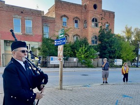 Steve Wolfe pipes at the farewell ceremony for the Paisley Inn in Paisley, Ont. on Monday, Sept. 13, 2021. Demolition of the inn, shown here across the street, has begun.(Sylvia Kirkwood photo)