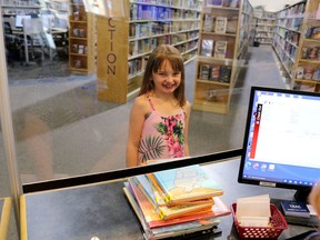 A young patron checking out her library books.