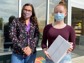 Melanie de Andrades, Fund Development and Marketing Administrative Assistant, with Madison Broussard, the Poetry in Motion Youth winner for 2020.  Broussard received an iPad donated by the City of Airdrie for her poem The Dreary Flower. Courtesy of Airdrie Public Library