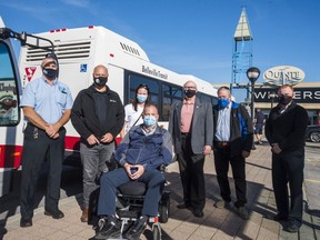 Paul Buck, manager of transit operations for the city of Belleville, seen front, centre, poses alongside local city leaders Tuesday at the Quinte Mall bus stop in Belleville, Ontario. ALEX FILIPE