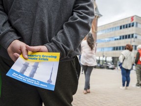 A Fridays for Future protest attendee holds a climate crisis pamphlet as they listen to the youth speakers advocate for immediate climate action at their rally held in Market Square behind Belleville City Hall Friday in Belleville, Ontario in part of the international Fridays for Future protests inspired by climate activist Greta Thunberg. ALEX FILIPE