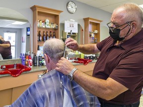 John Romano gives a haircut to Wayne Villamere of Brantford, who was the barber's first client at Capelli's barber shop. Romano has been cutting hair in Brantford for 58 years.