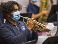 Arka Banerjee plays a trumpet - fitted with a furnace filter over the bell end -- in the instrumental music class at Assumption College School in Brantford.