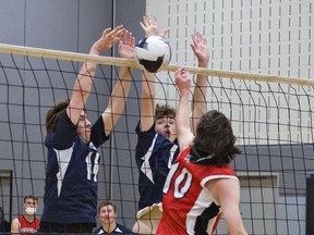 Carson Burr of the Paris Panthers (#10) faces a block by Aiden Waite (left) and Damon Nixon of the Assumption Lions during a high school senior boys volleyball match on Thursday September 23, 2021 in Brantford, Ontario. Brian Thompson/Brantford Expositor/Postmedia Network