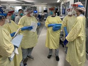 Registered nurses in the critical care ward of Brantford General Hospital huddle before entering a COVID-19 patient's room.