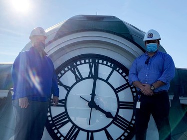 Brockville Mayor Jason Baker, left, and city facilities supervisor Les Johnston pose by the main clock face on the Victoria Building clock tower on Tuesday morning. (RONALD ZAJAC/The Recorder and Times)
