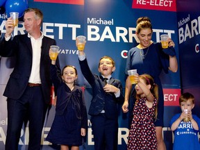 Conservative MP-elect Michael Barrett and his family raise their glasses towards the crowd of supporters at Luna Pizzeria after Barrett was re-elected in the local riding shortly after 10:30 p.m. on Monday.
