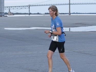 With the Ogdensburg-Prescott International Bridge in the background, Anne Hodgson makes her way along the 5-km Twilight Fun Run course at the Port of Johnstown.
Tim Ruhnke/The Recorder and Times