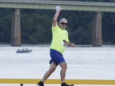 Rob Wright waves as he makes his way along the waterfront portion of the 5-km fun run route at the Port of Johnstown.
Tim Ruhnke/The Recorder and Times